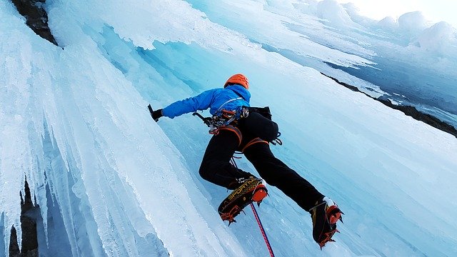 Ice Climber scaling the ice - Extreme Sports